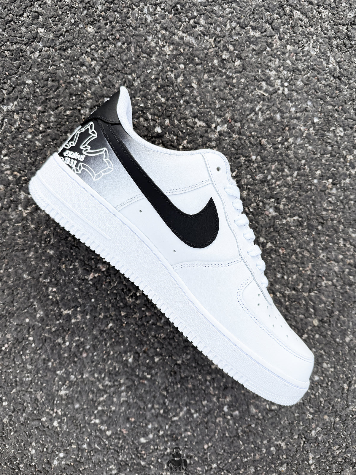 Side profile of handmade Nike Air Force 1 custom sneakers with realistic Tupac portrait and black Nike Swoosh detail