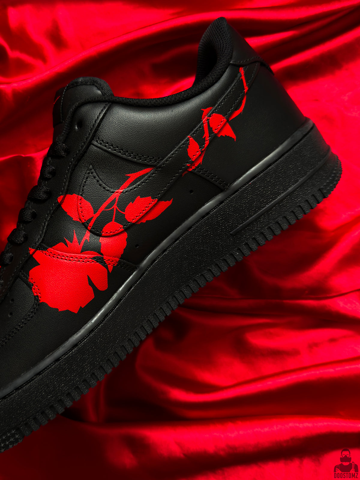 Close-up of black Nike Air Force 1 with detailed hand-painted red rose artwork