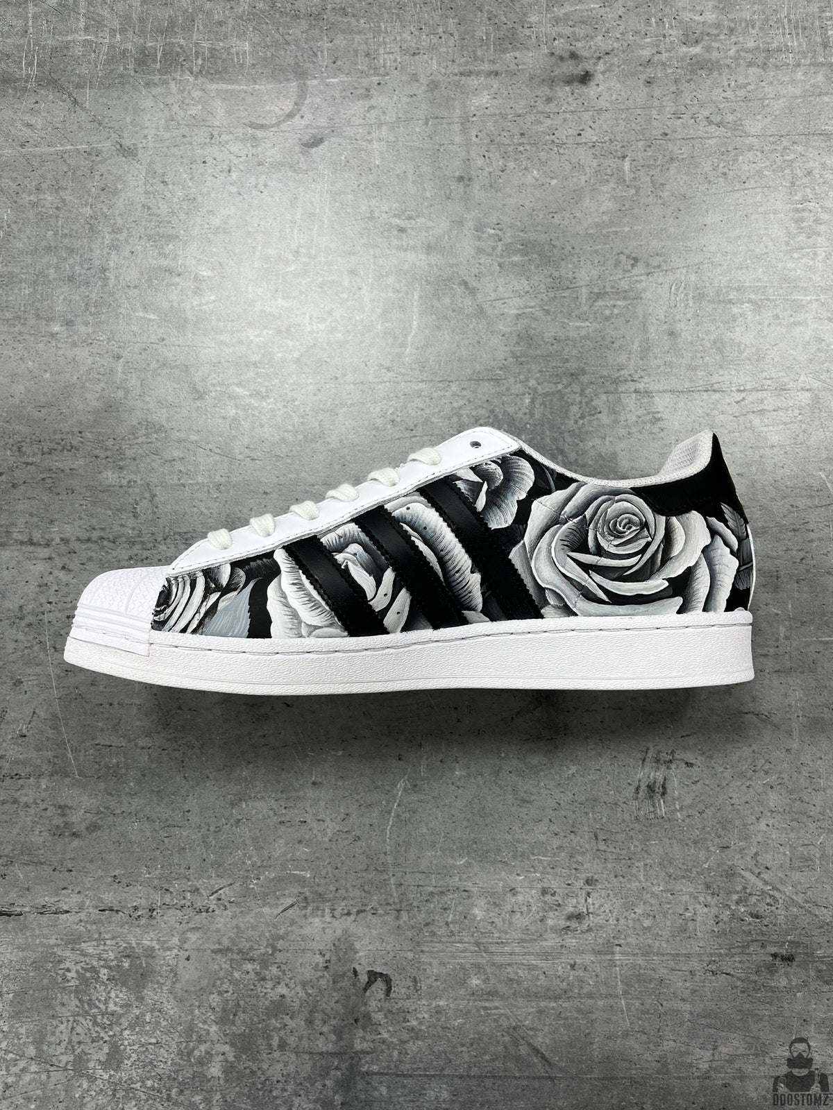 Side view of Adidas Superstar Black & White Roses Custom sneakers featuring detailed hand-painted roses and black stripes