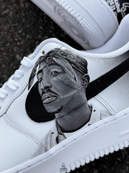Close-up view of hand painted Tupac Shakur artwork on Nike Air Force 1 sneakers with detailed black and grey portrait shading
