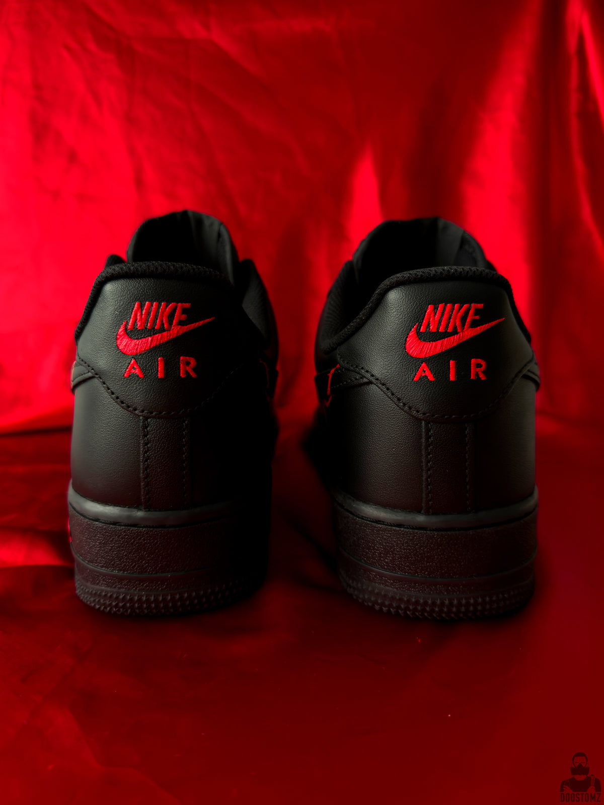 Back view of black Nike Air Force 1 custom sneakers with red Nike Air branding