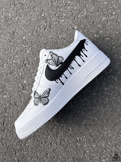 Custom Nike Air Force 1 Sneakers featuring black dripping paint and detailed black and white butterflies