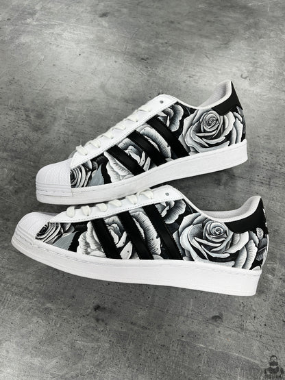Pair of Adidas Superstar Black & White Roses Custom sneakers with monochrome floral artwork and white shell toes