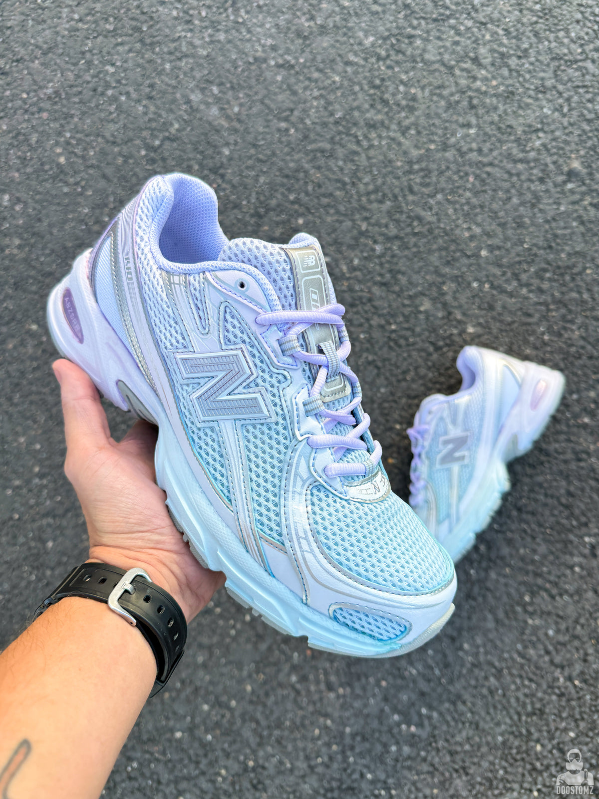 New Balance 740 custom sneakers in blue and lavender gradient, handmade custom sneaker held in hand