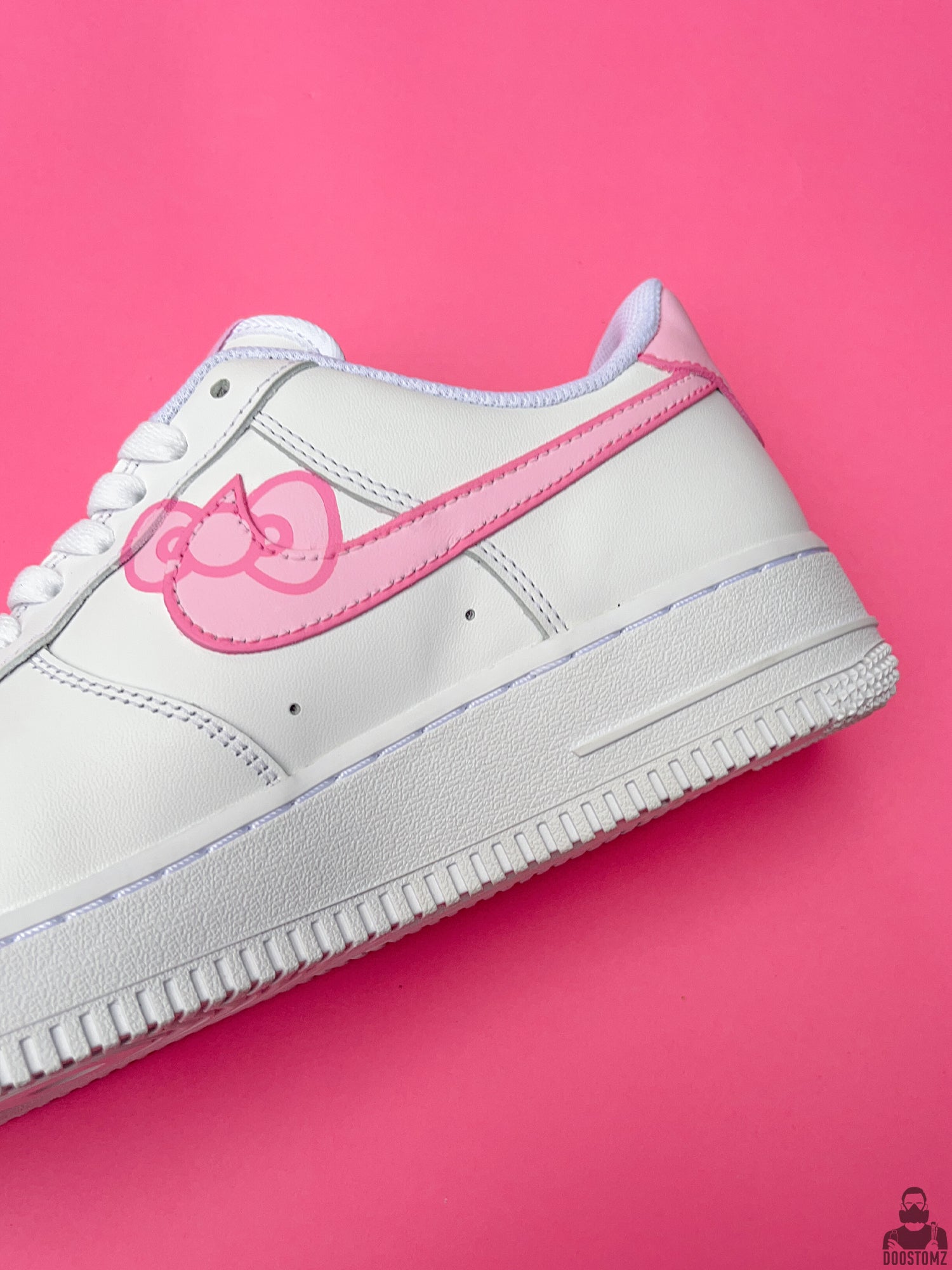 Close-up of Nike Air Force 1 Hello Kitty Custom sneakers showing hand-painted pink artwork and white leather details