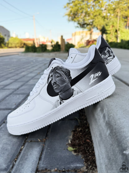 Custom Nike Air Force 1 Low sneakers displayed outdoors showing hand painted 2Pac artwork and monochrome streetwear style
