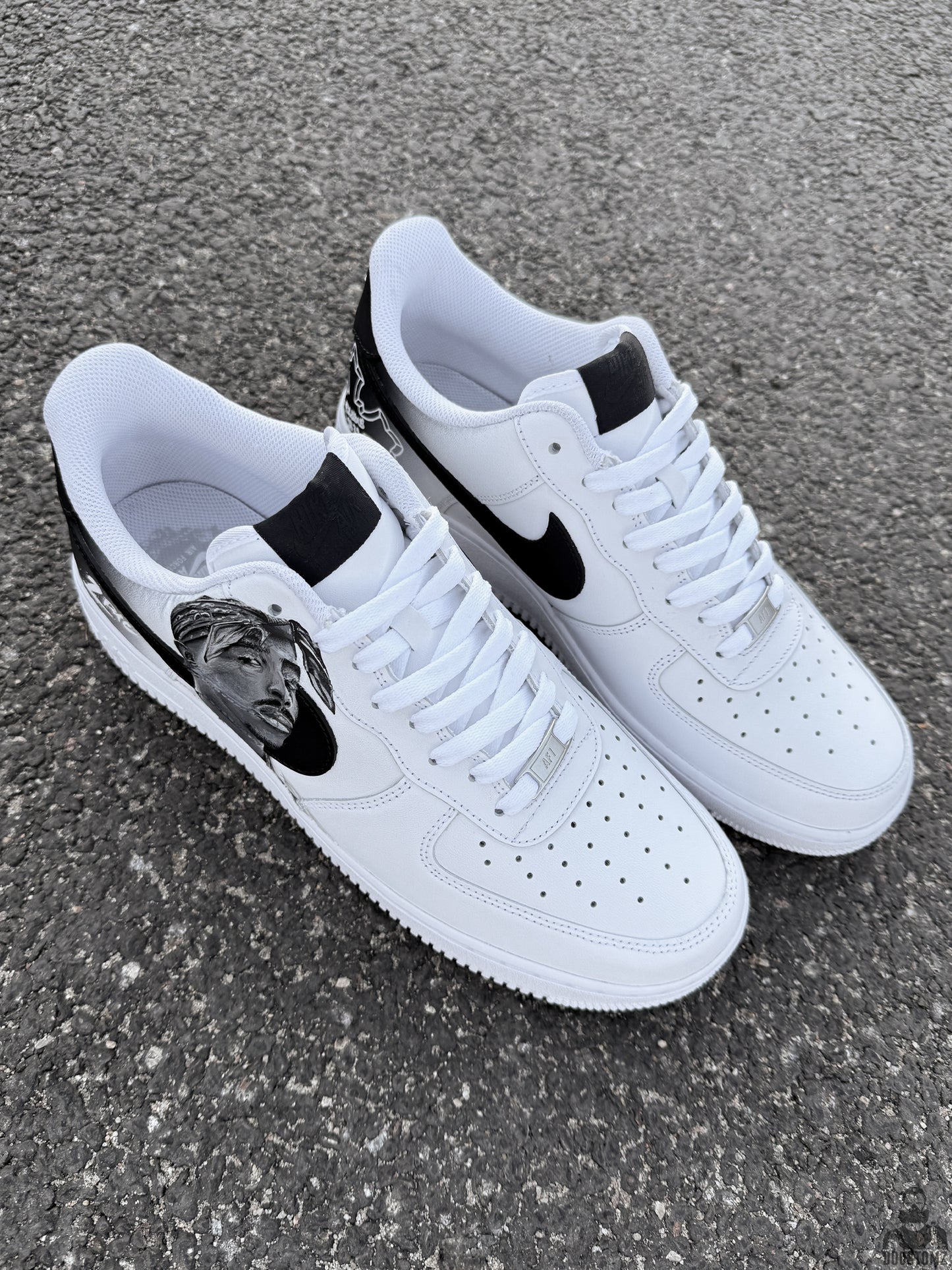 White Nike Air Force 1 custom sneakers with black accents, hand painted Tupac portrait and detailed custom heel artwork