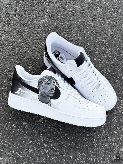 Pair of custom Nike Air Force 1 shoes featuring black and white hand painted Tupac Shakur inspired artwork on both sneakers